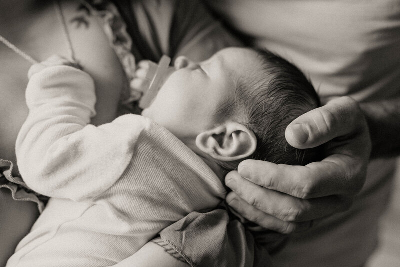 Newborn baby being cradled by parents
