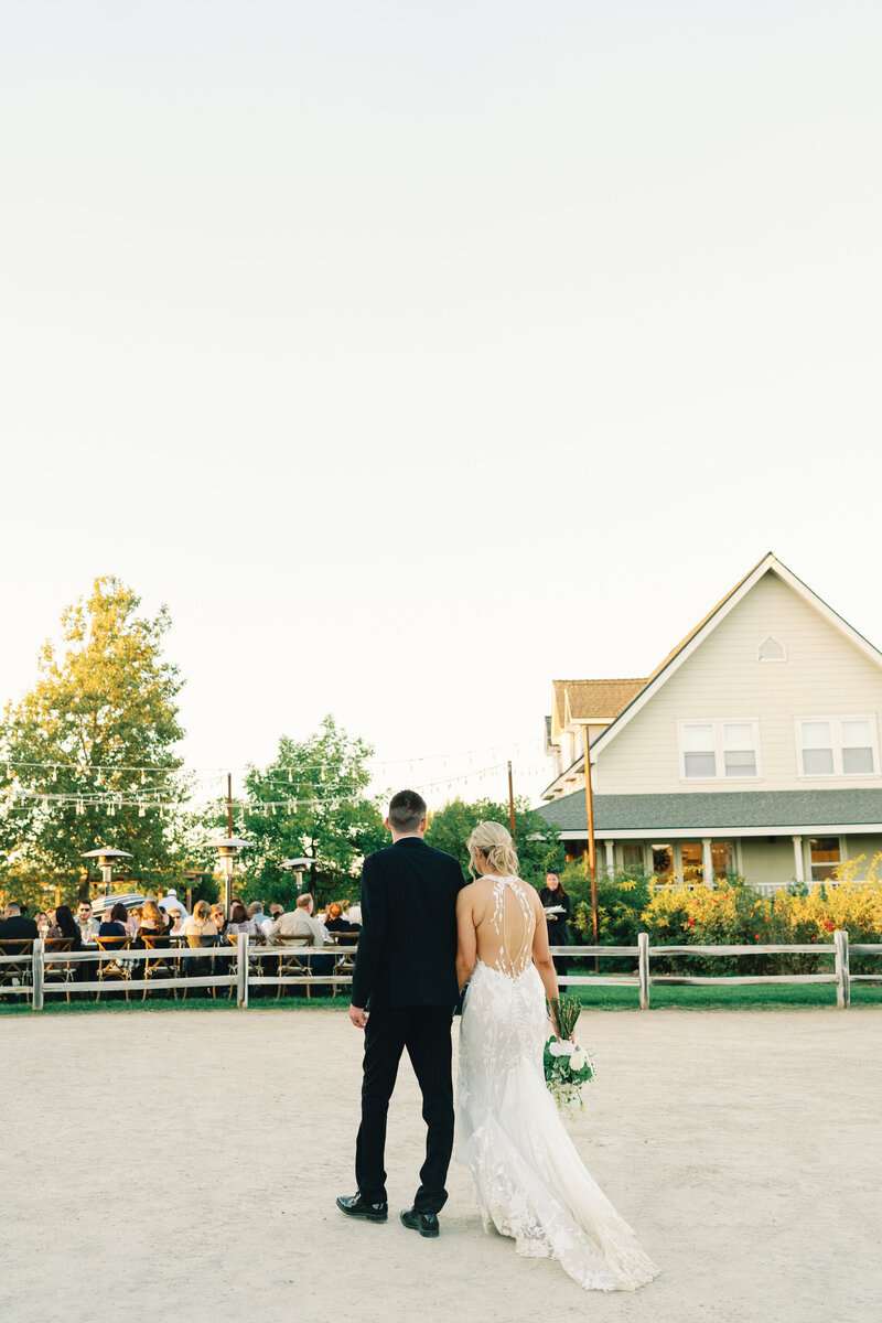 bride and groom walk back to reception after their golden hour portraits