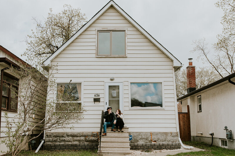 Couple sitting in front of their house