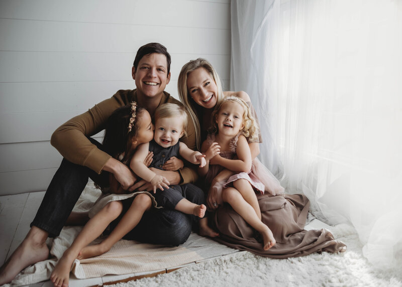 Casey Howard, newborn photographer, with her family in white studio