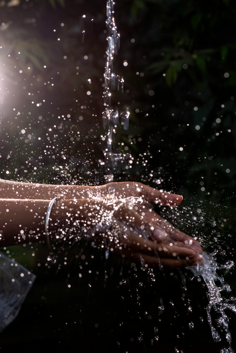 Image of hands cupping water as it falls from above