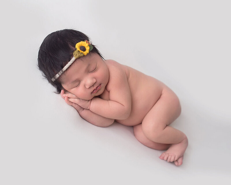 Newborn portrait in sunflower headdress by Laura King