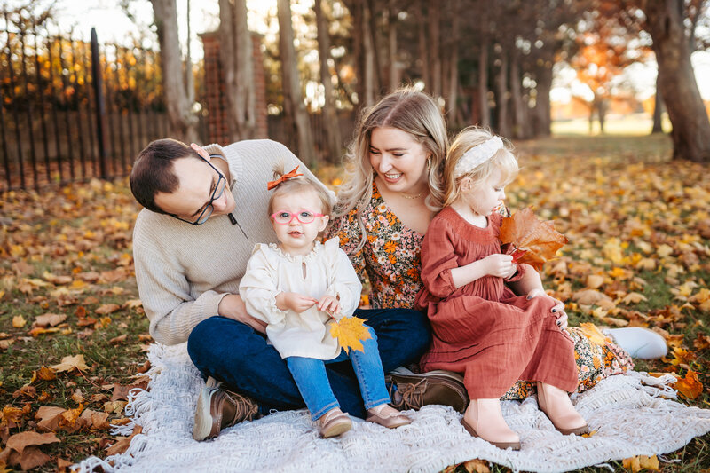 Young family sitting in leaves