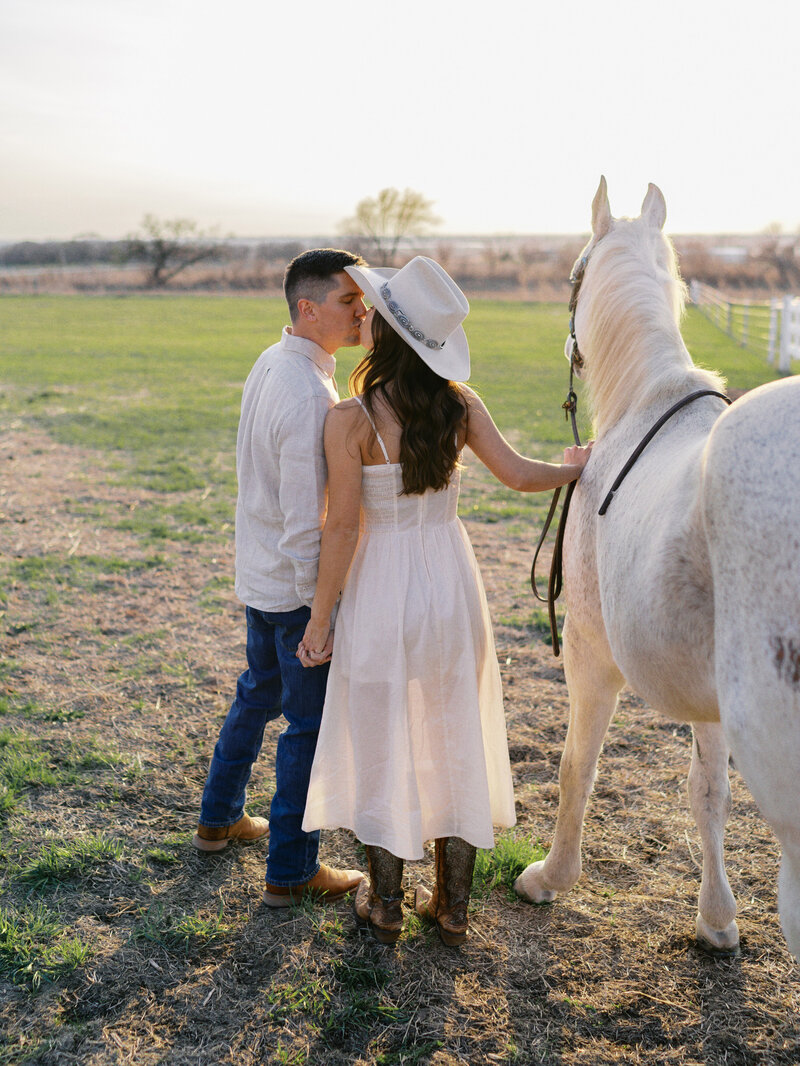 engaged-couple-kissing-with-horse