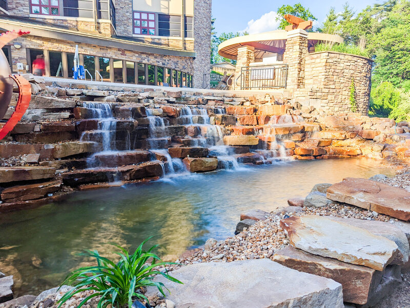 Serene waterfalls cascading down a large stone water feature in front of Sundara Inn and Spa Wisconsin Dells