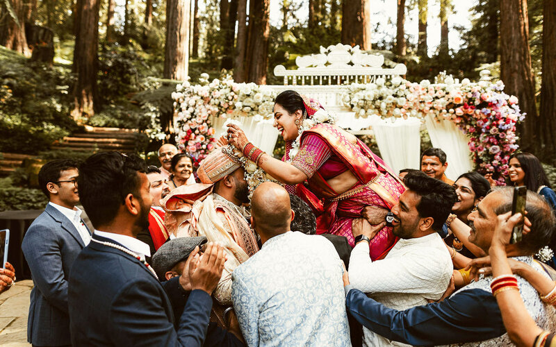 Emotional candid moment from Indian wedding ceremony with bride lifted by guests