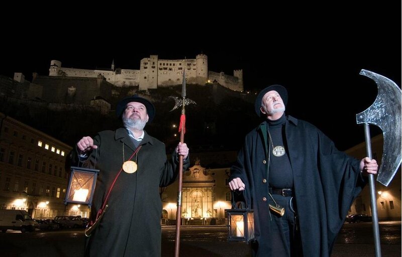 Nachtwächter in traditioneller Tracht hält eine Laterne während der nächtlichen Führung