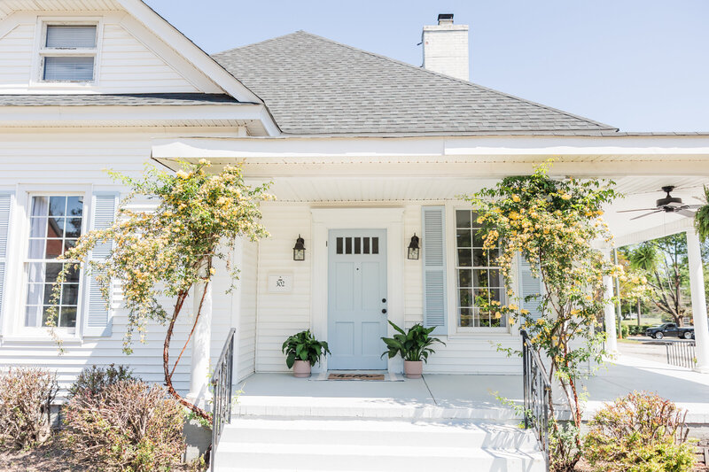 a white and blue house that has been converted into a photography studio