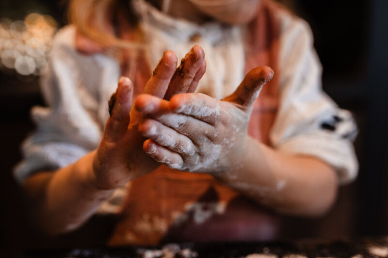 handjes van meisje vol met deeg en bloem draaien pepernoten