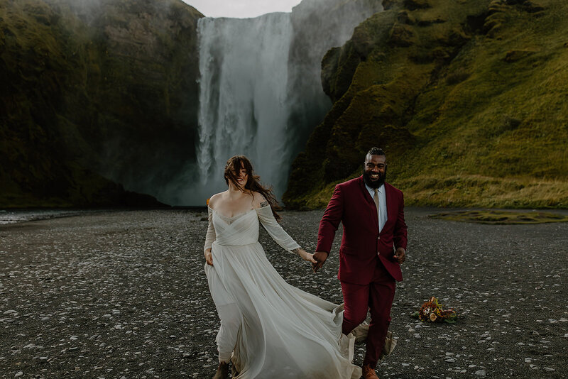 Bride's dress going crazy in the wind during their Skogafoss Elopement in Iceland
