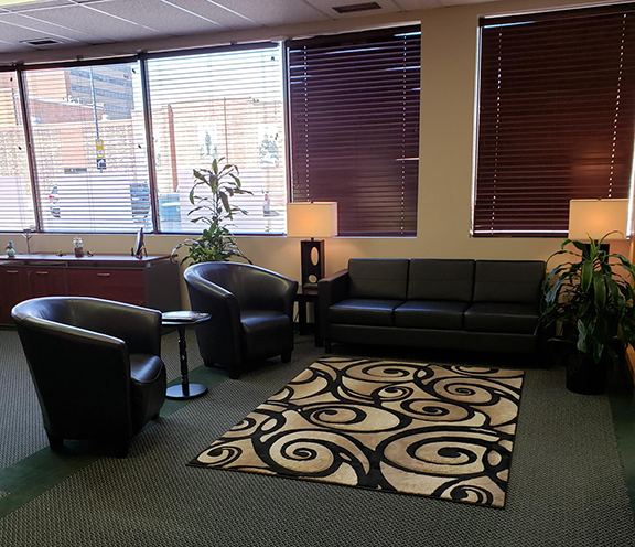 The entrepreneurial centre at execuserv plus inc has two chairs and a couch for casual sitting.