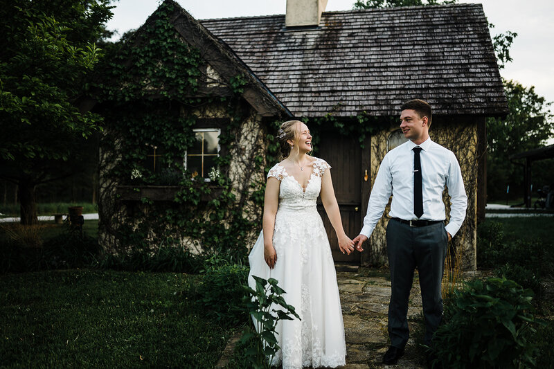 Happy young newly married couple looking at each other at beautiful garden wedding.