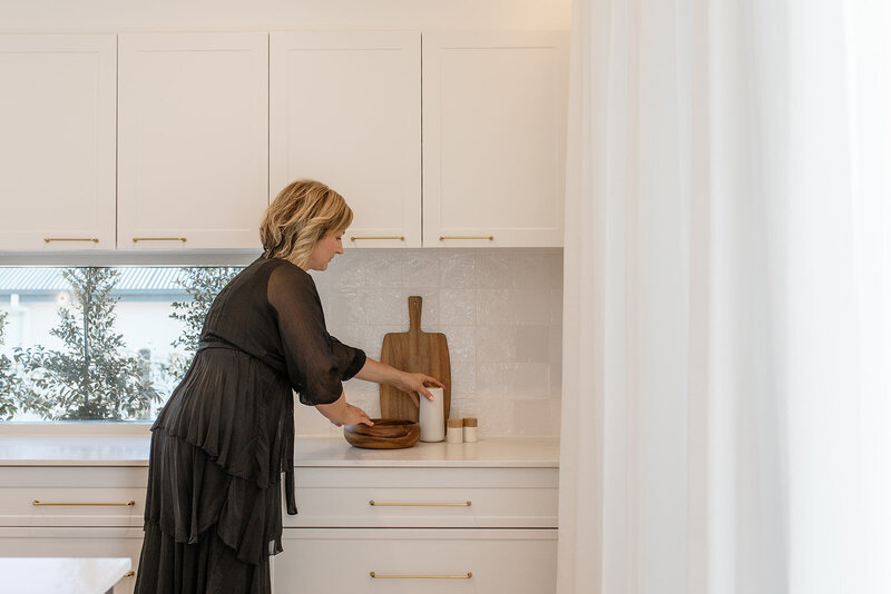 Lady standing in kitchen with props