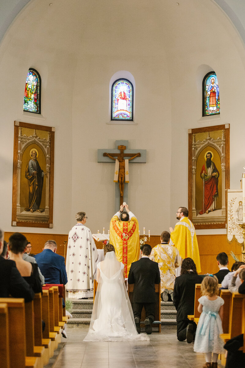 Bride and groom kneeling during their wedding ceremony