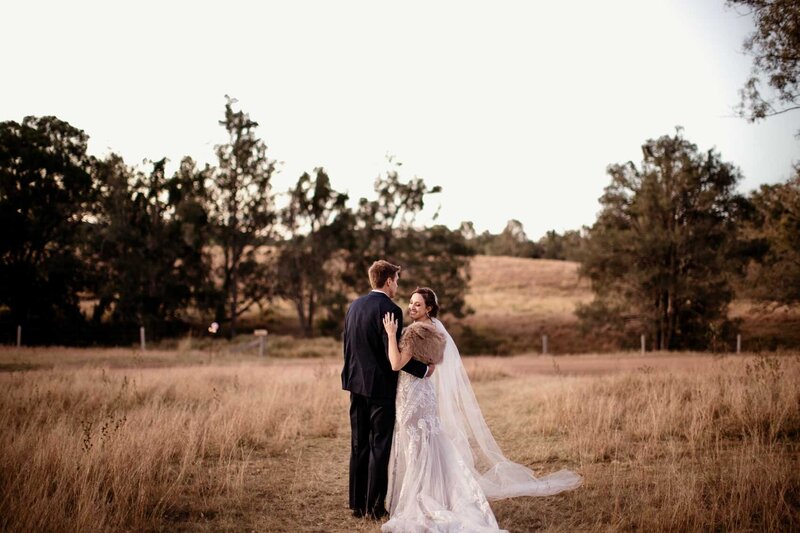 Bride and groom holding each other at mountain farm