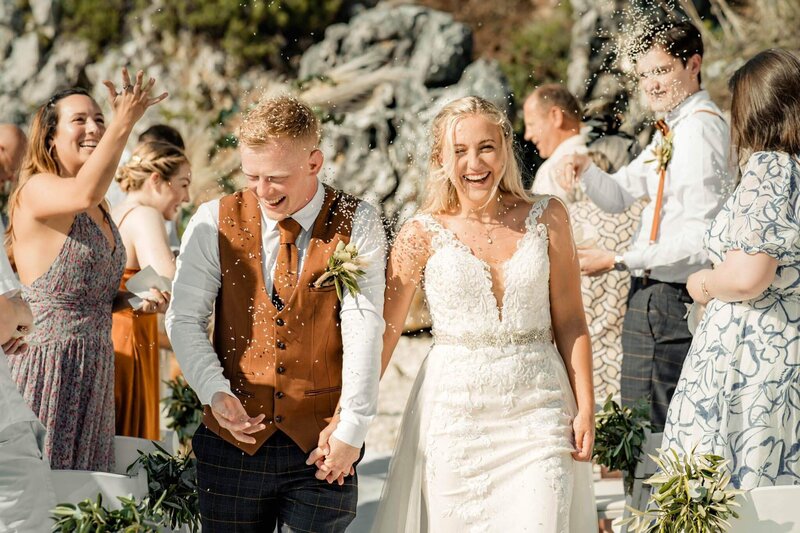 Yorkshire Wedding Photographer & Videographer capturing a beach wedding ceremony in Corfu, Greece, as guests throw rice for good luck.