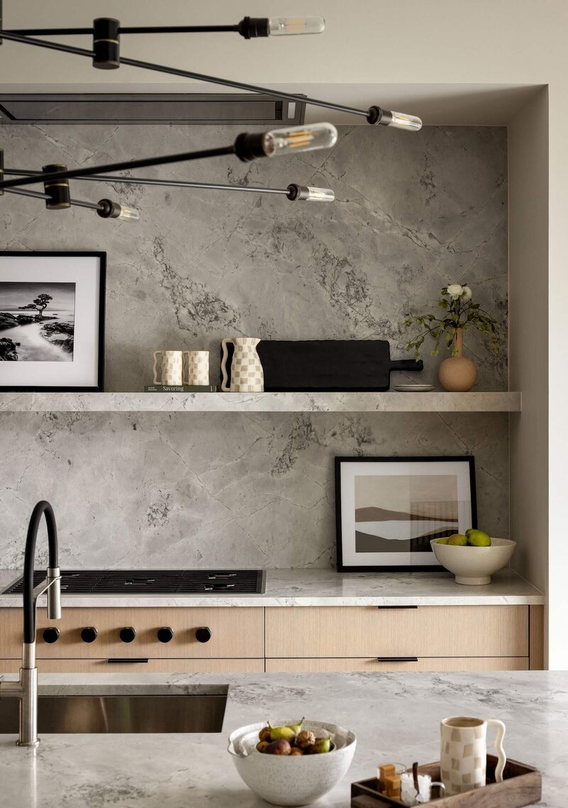 Sophisticated Japandi-style kitchen featuring natural materials—white oak cabinets, quartzite counters, and oversized pendant lights.