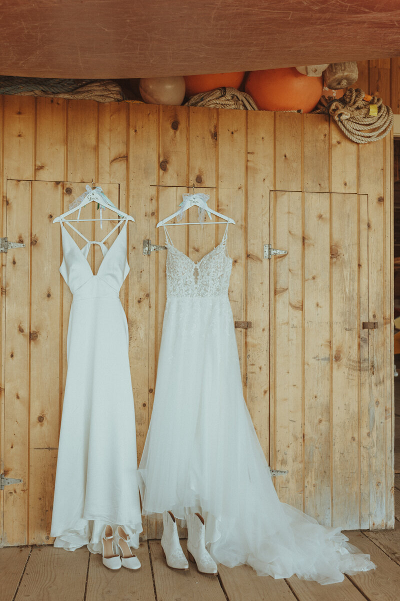 Two brides’ wedding dresses hanging side by side at a Portland, Oregon LGBTQ+ wedding, photographed by Bare Bones Photo