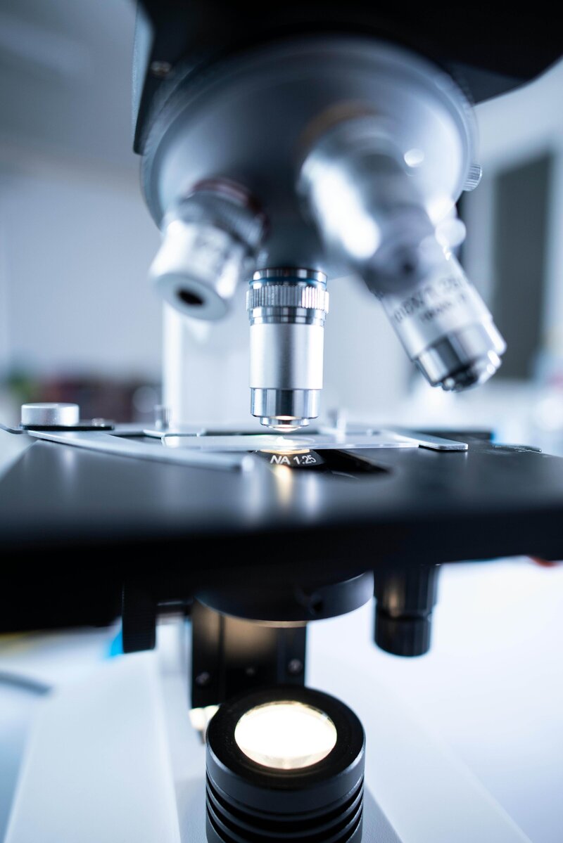 A sleek silver microscope in a laboratory setting, focused on the lens, representing scientific exploration and innovation.