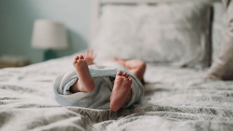 a newborn baby lying on a bed