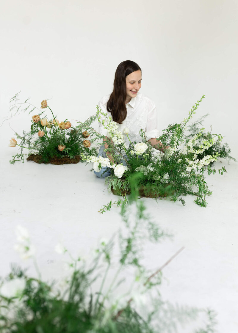 woman crouching down near flowers