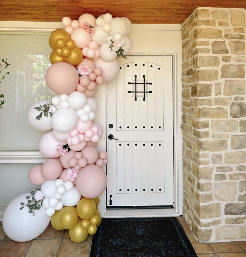 White, pink and gold balloon arch with greenery