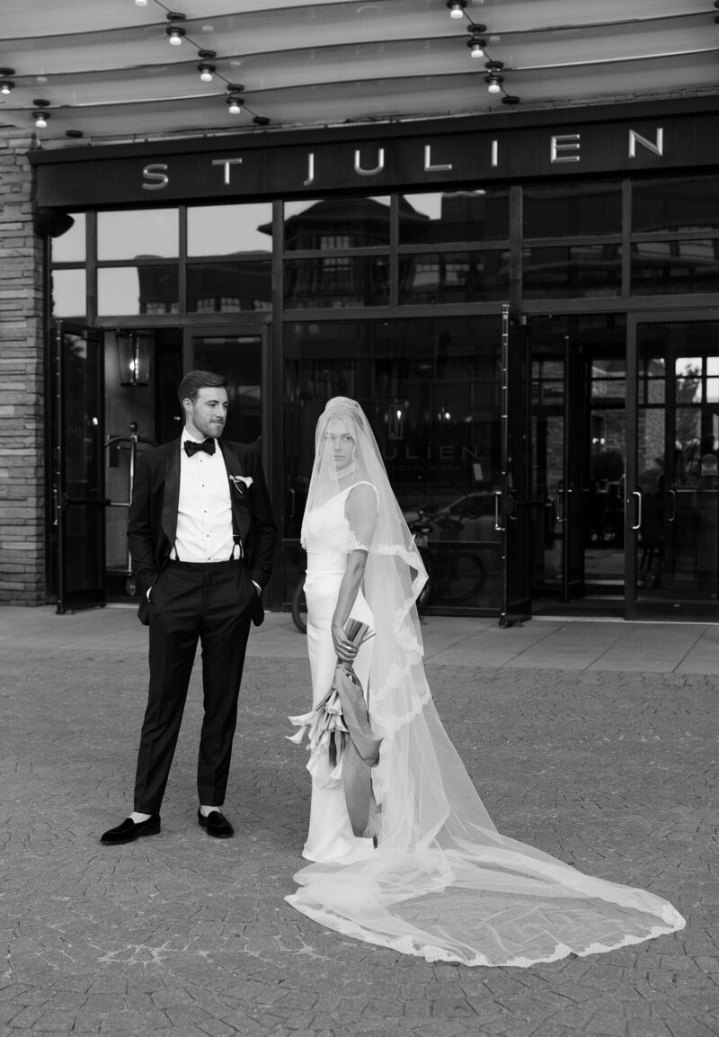 couple in wedding dress and suit walk by camera linking arms