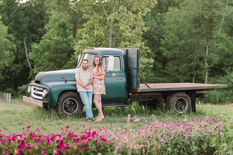 couple standing together by an antique truck at country joy flowers mini sessions by lancaster pa photographer