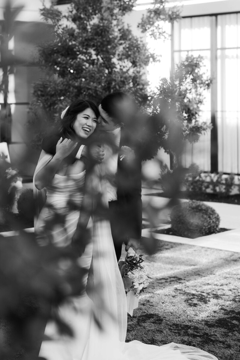 Black and white image of a bride and groom having their first dance looking at each other