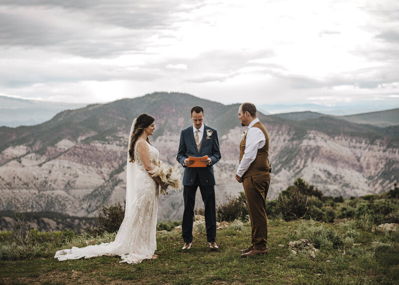 bride and groom kissing with brides veil flowing in the wind
