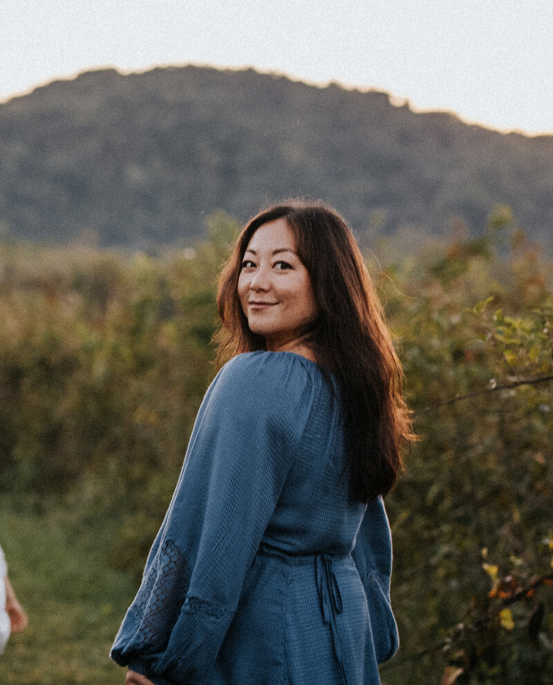lindsay schroeder of fabled light photography looking over shoulder in nature scene taken by iris hu