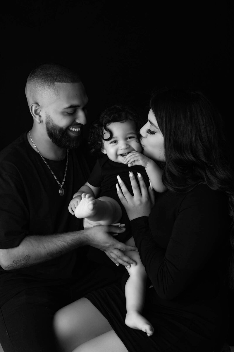 A black and white image of a family posed with a baby in a Vancouver Photography Studio