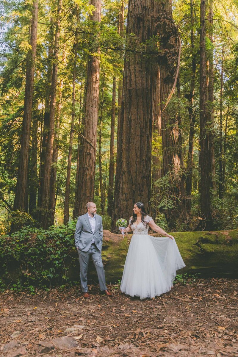 A Big Sur bride and groom do a trust fall during the pink sunset.