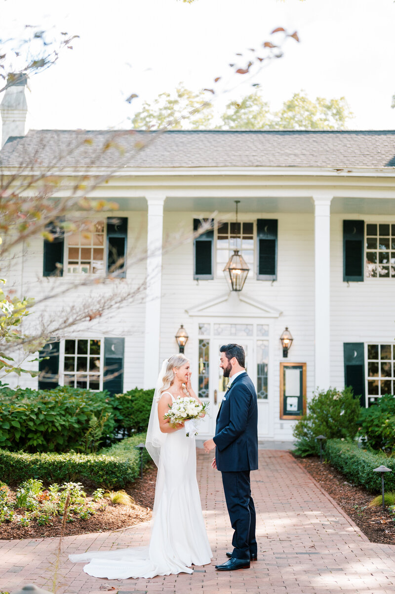 Couple holding hands in front of fearrington house private vows before ceremony