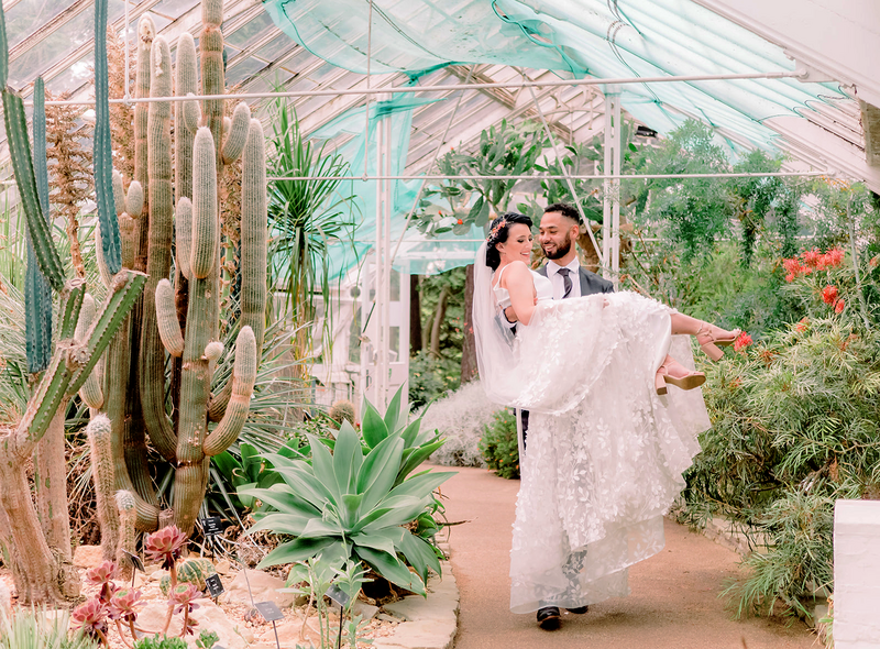 groom lifts bride at the botanical gardens wedding venue
