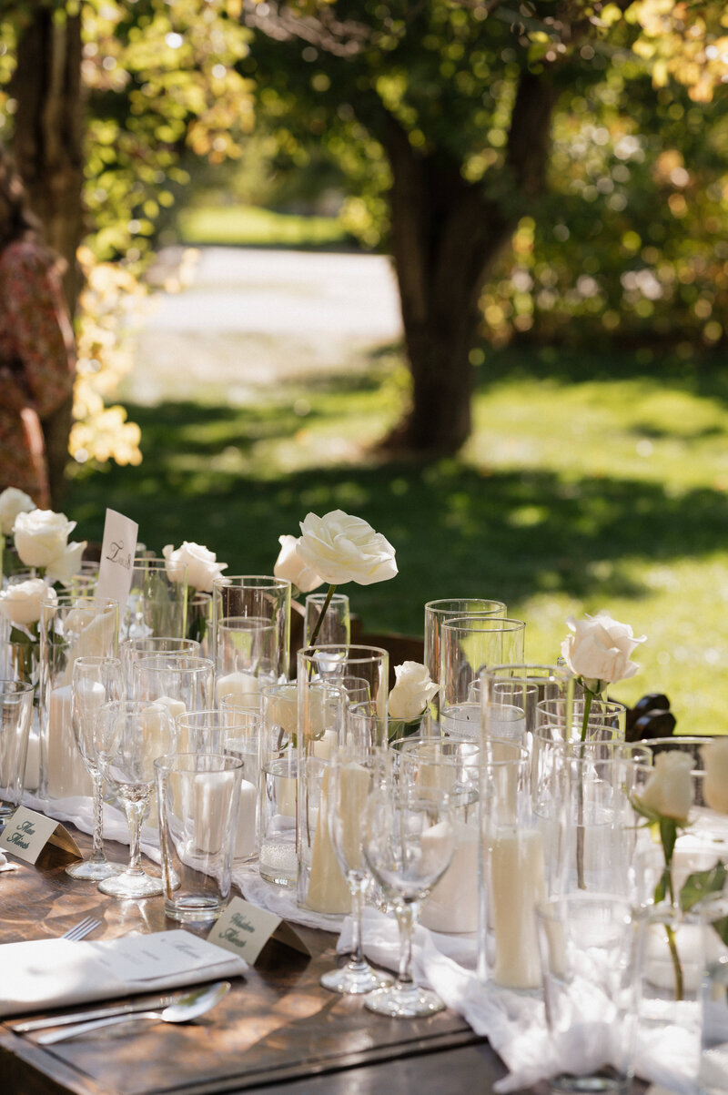 An exclusive Idaho wedding reception, featuring a high-end table setting with lush florals, neutral tones, and a romantic mountain backdrop.
