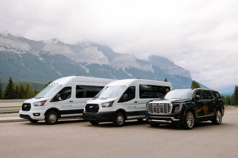 Wedding transportation fleet in Canmore featuring Ford Transit shuttles and GMC Yukon Denali with Rocky Mountain views.