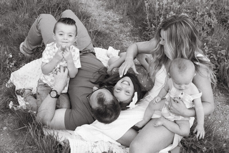 A family snuggled up on a blanket at.