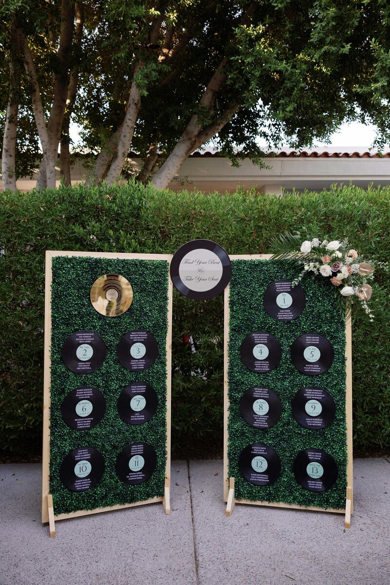 Seating chart at a Scottsdale wedding with vinyl records listing guest’s name and table number.