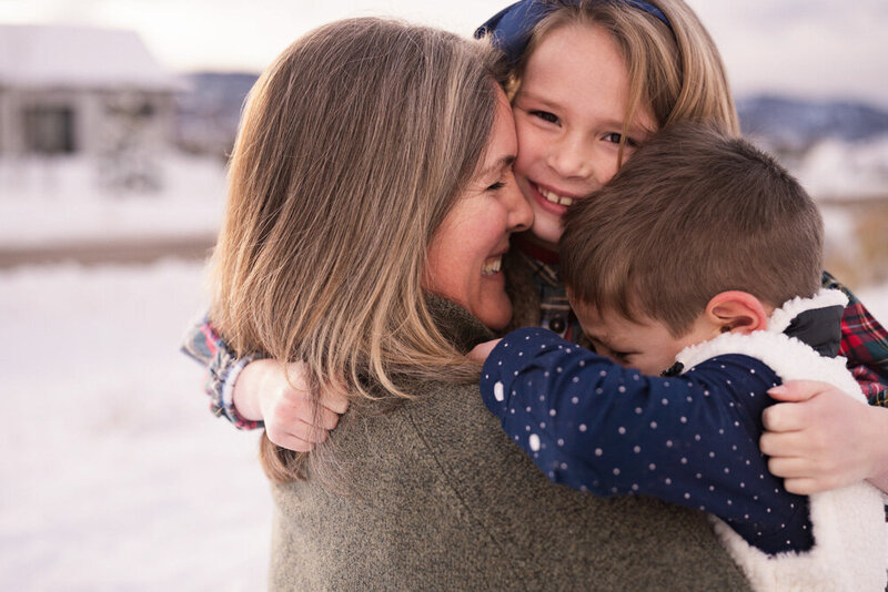 Mom and her two children get in close for a fun hug