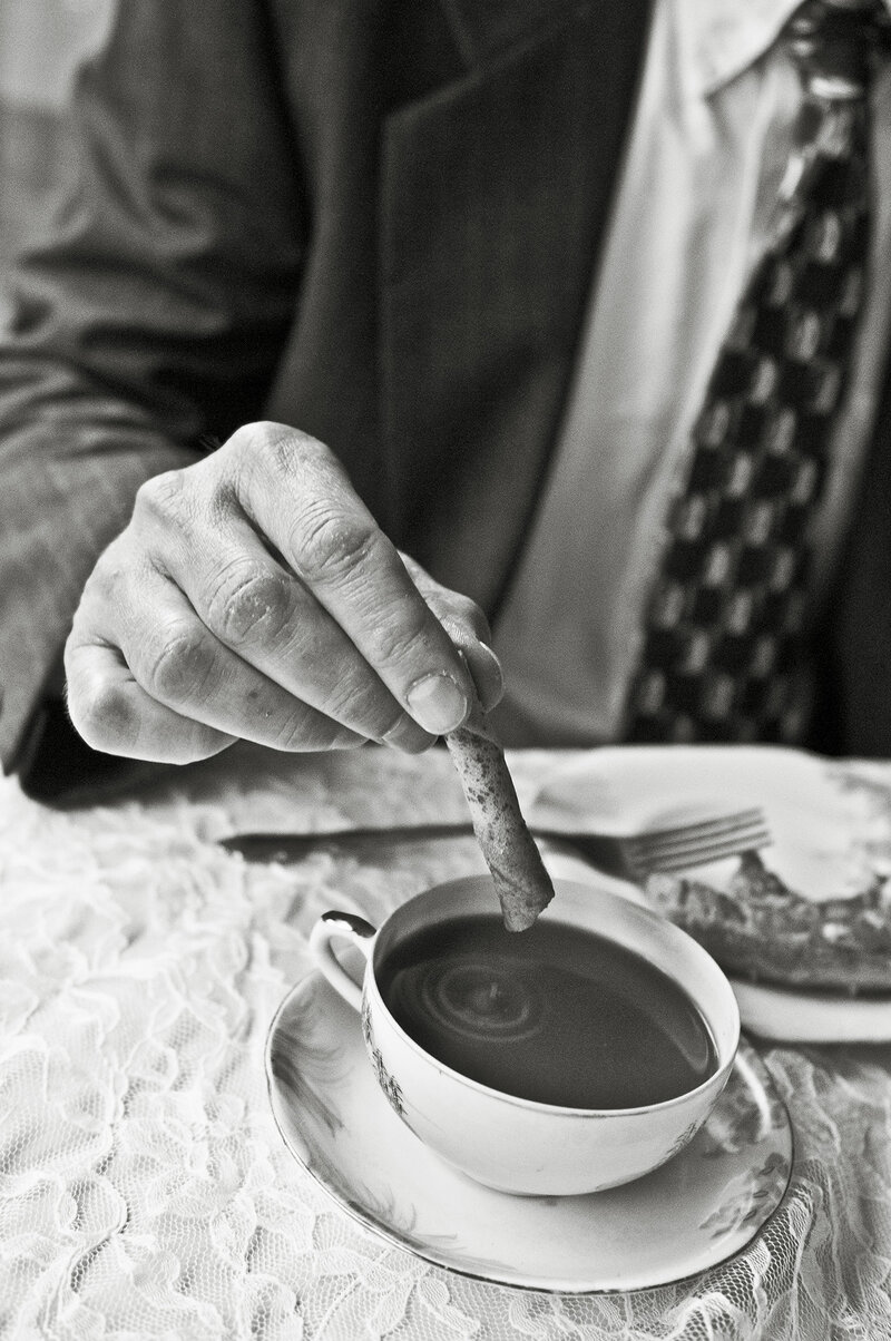 A person dipping a biscotti into a coffee