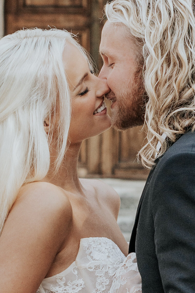 Blonde husband and wife kiss on wedding day