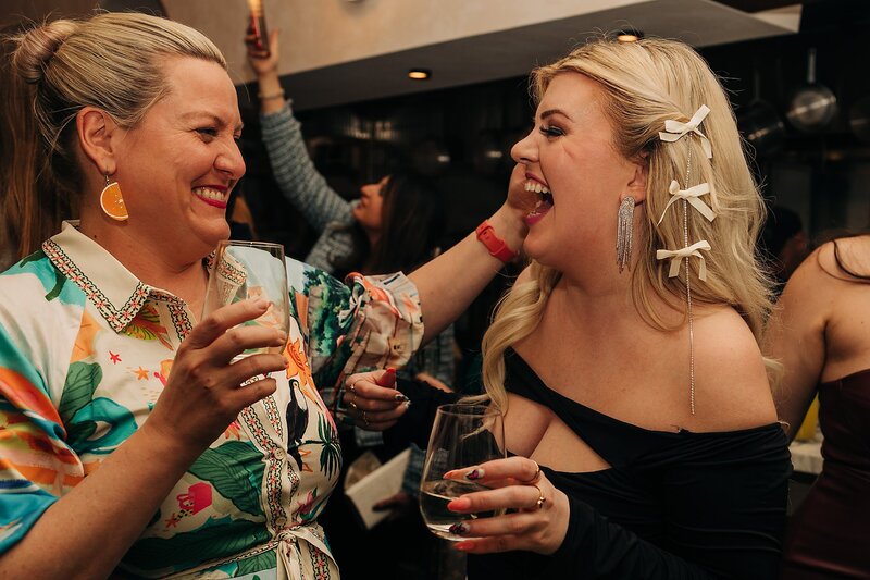Friends toasting and celebrating during Dart Collective Chicago launch at Lou Lou by Lola Cafe