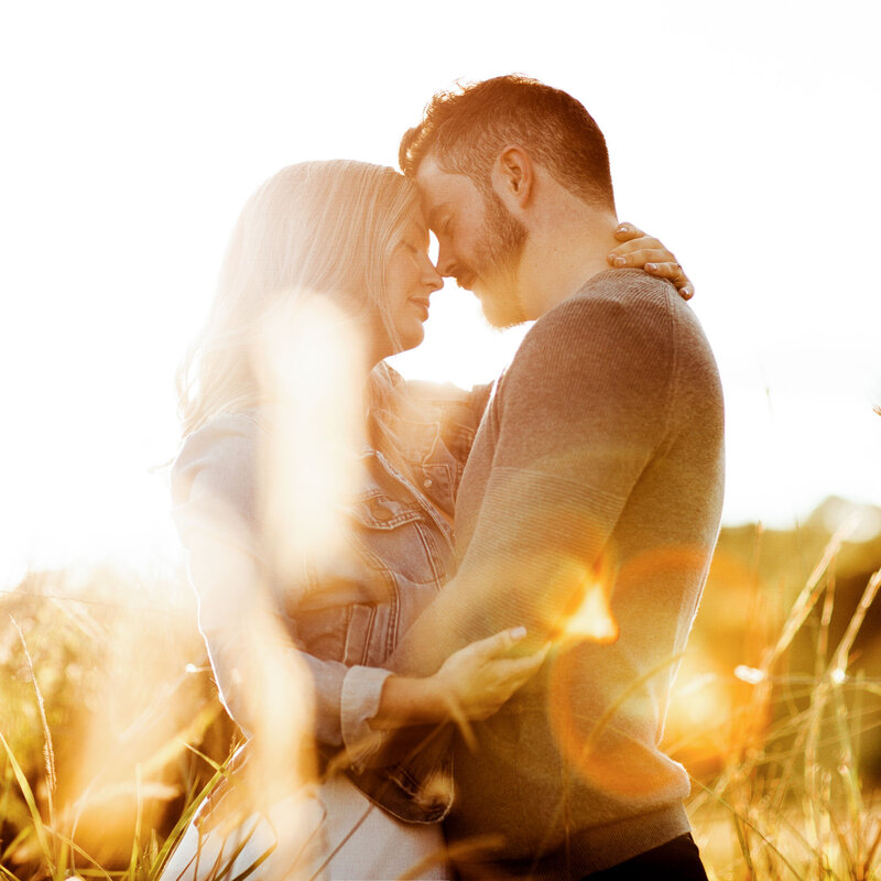 Engagement couple passionately hold each other under the sunset