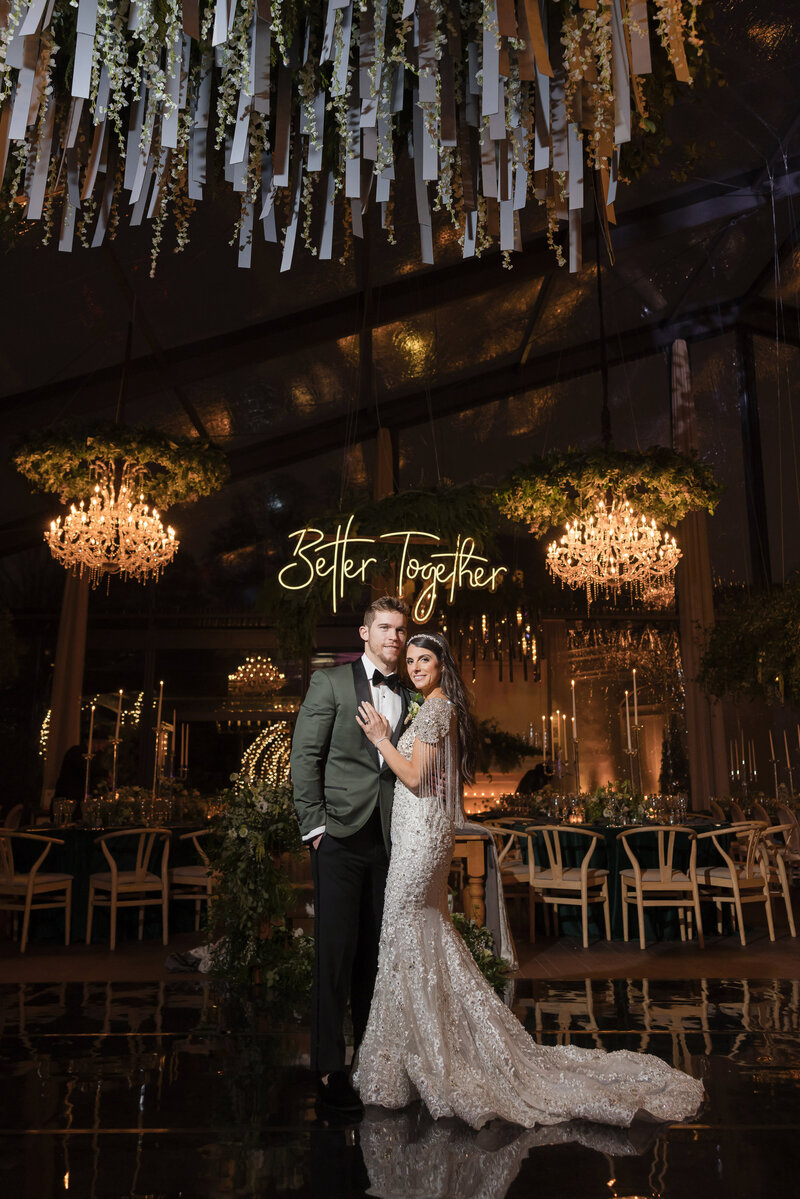 A side angle photo of a Down Town Club ballroom with tons of candles and white roses.