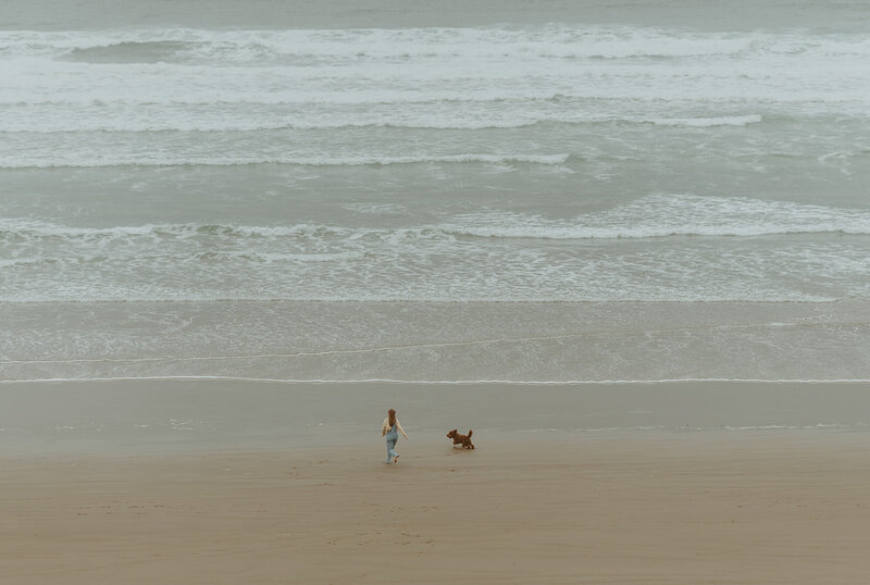 girl and dog running on the beach at the oregon coast