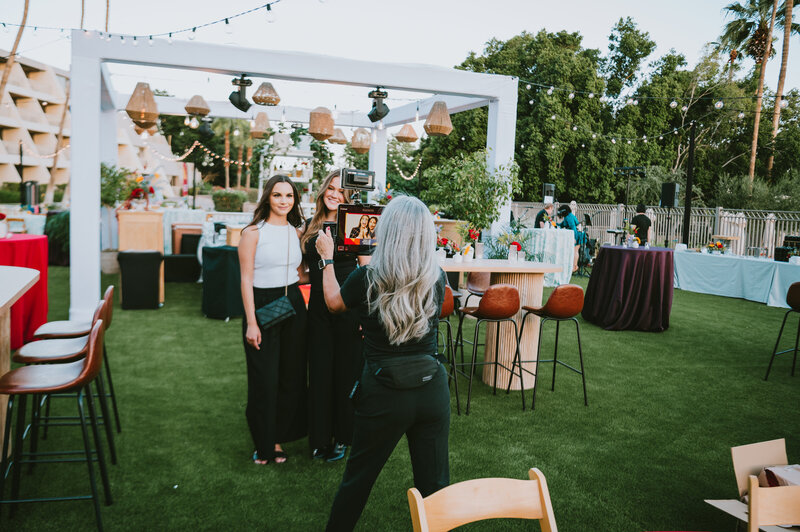 MISGIF roaming photo booth attendant capturing guests at an upscale outdoor corporate event in Phoenix, Arizona, featuring a stylish garden setup and natural lighting