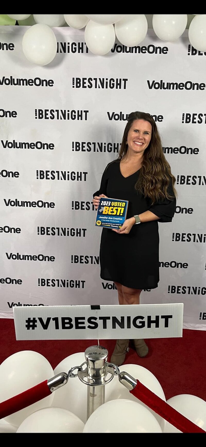 Jennifer holding the VolumeOne "Best Of" 2023 award.