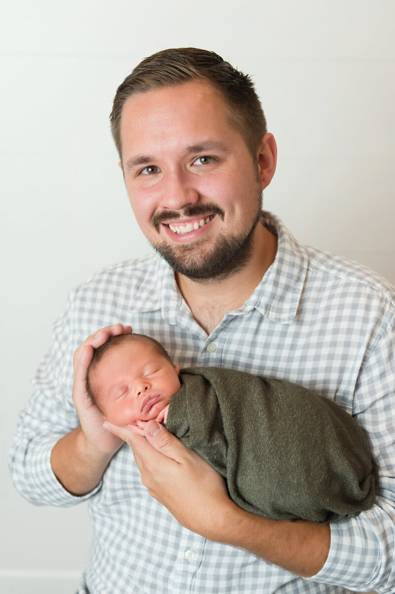 Newborn baby boy portrait with Dad durinf posed strudio session in Ocean County studio.