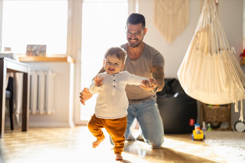 Papa encourageant son enfant dans ses premiers pas, symbolisant l’accompagnement parental bienveillant et la progression pas à pas proposée par La Roadmap.